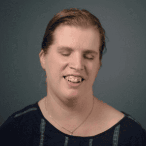 A headshot of Kristen Witucki wearing a gold necklace and a black shirt. 