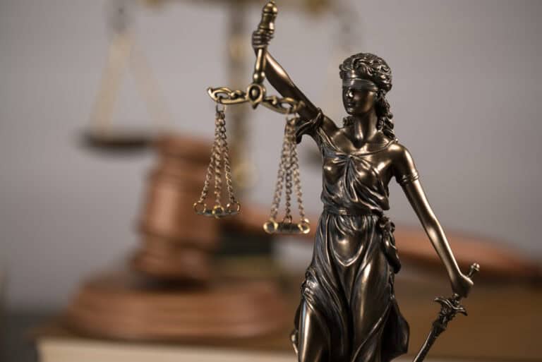 A statue of a blindfolded Lady Justice holding legal scales.